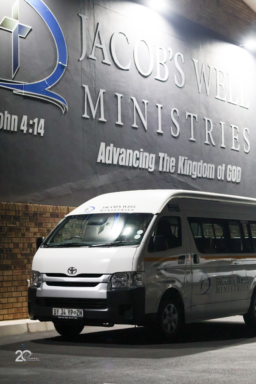 The Jacob's Well Ministries church building today with signage and ministry bus